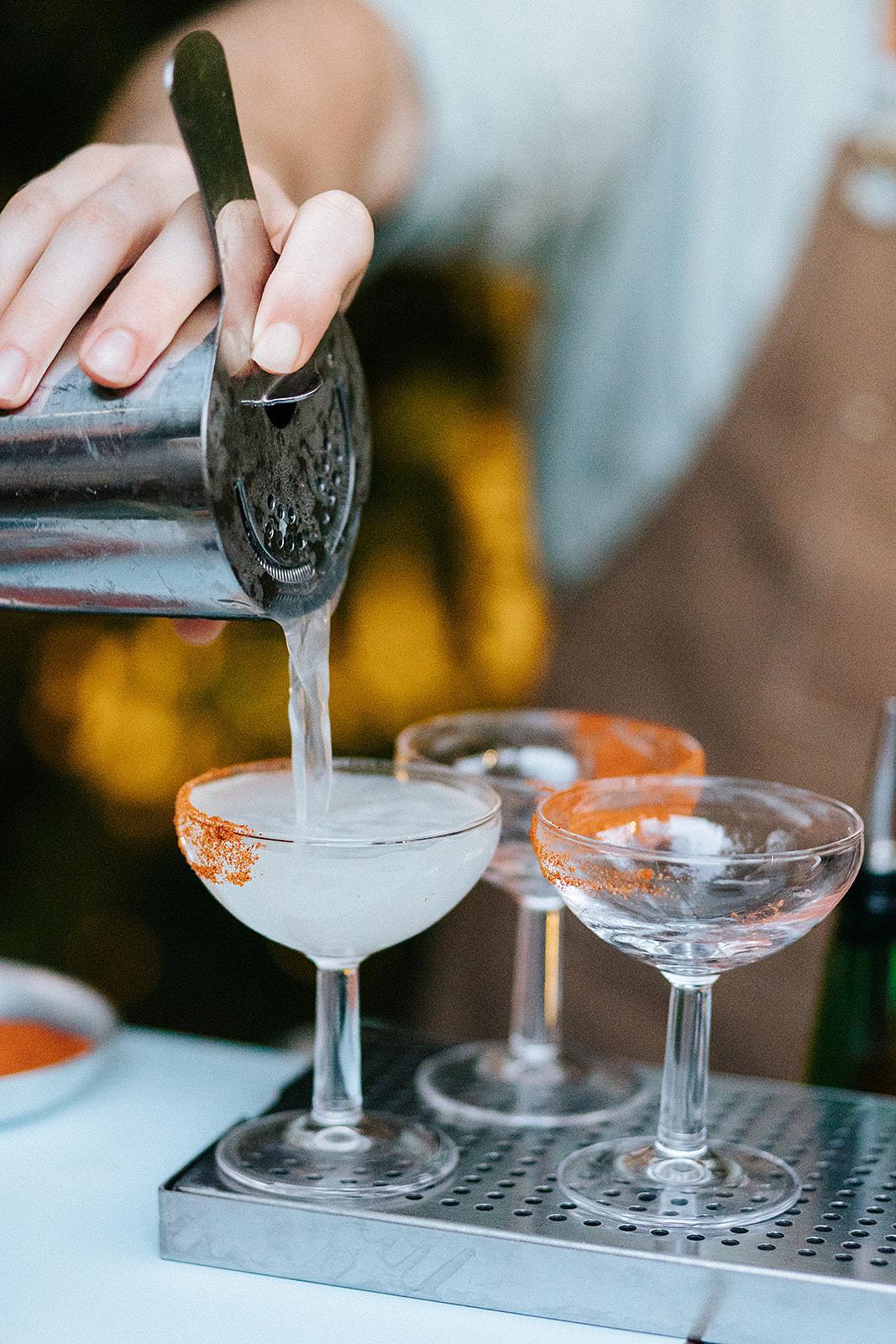 Pouring cocktails into coupe glasses